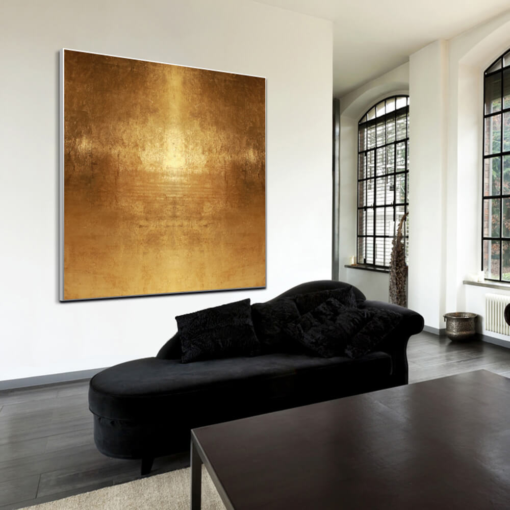 Goldenes quadratisches Akustikbild hinter einem Sofa