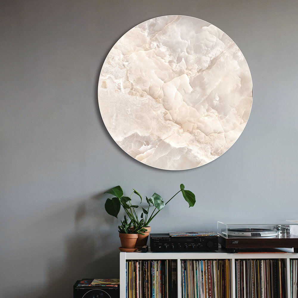 Rundes Akustikbild mit beigem Marmor Motiv im Wohnzimmer hängend über einem Plattenspieler