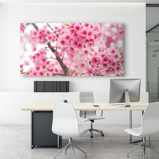 Rechteckiges Akustikbild mit Fotografie von rosa Kirschblüten hinter einem weißen Schreibtisch