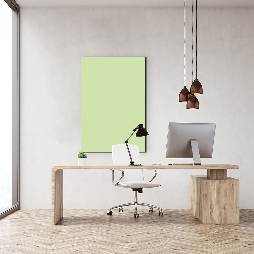 Rechteckiges Akustikbild in hellgrün hinter einem Schreibtisch